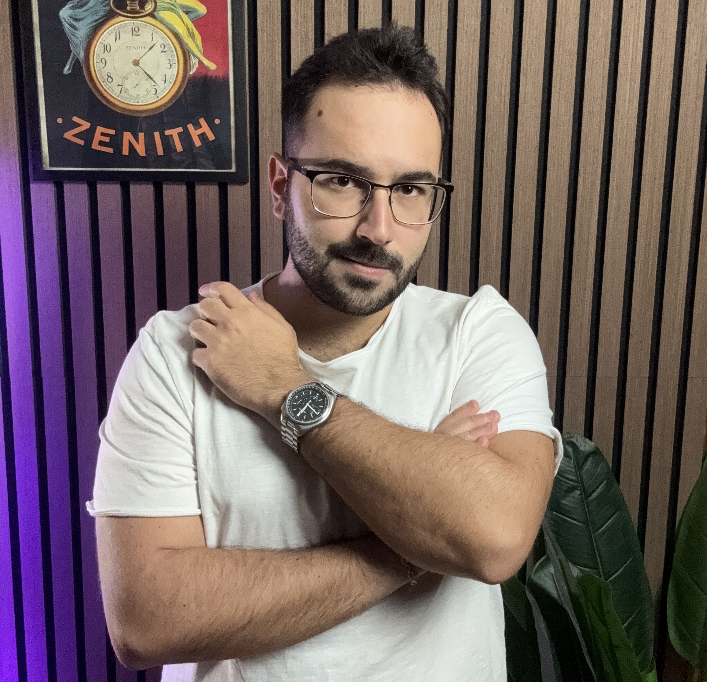 Portrait of Ferdinando Bonsegna wearing a chronograph, in front of a vintage Zenith poster.